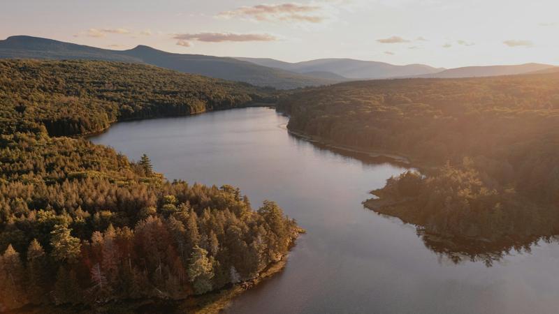 A river winding between forested hills in the Catskills at sunset